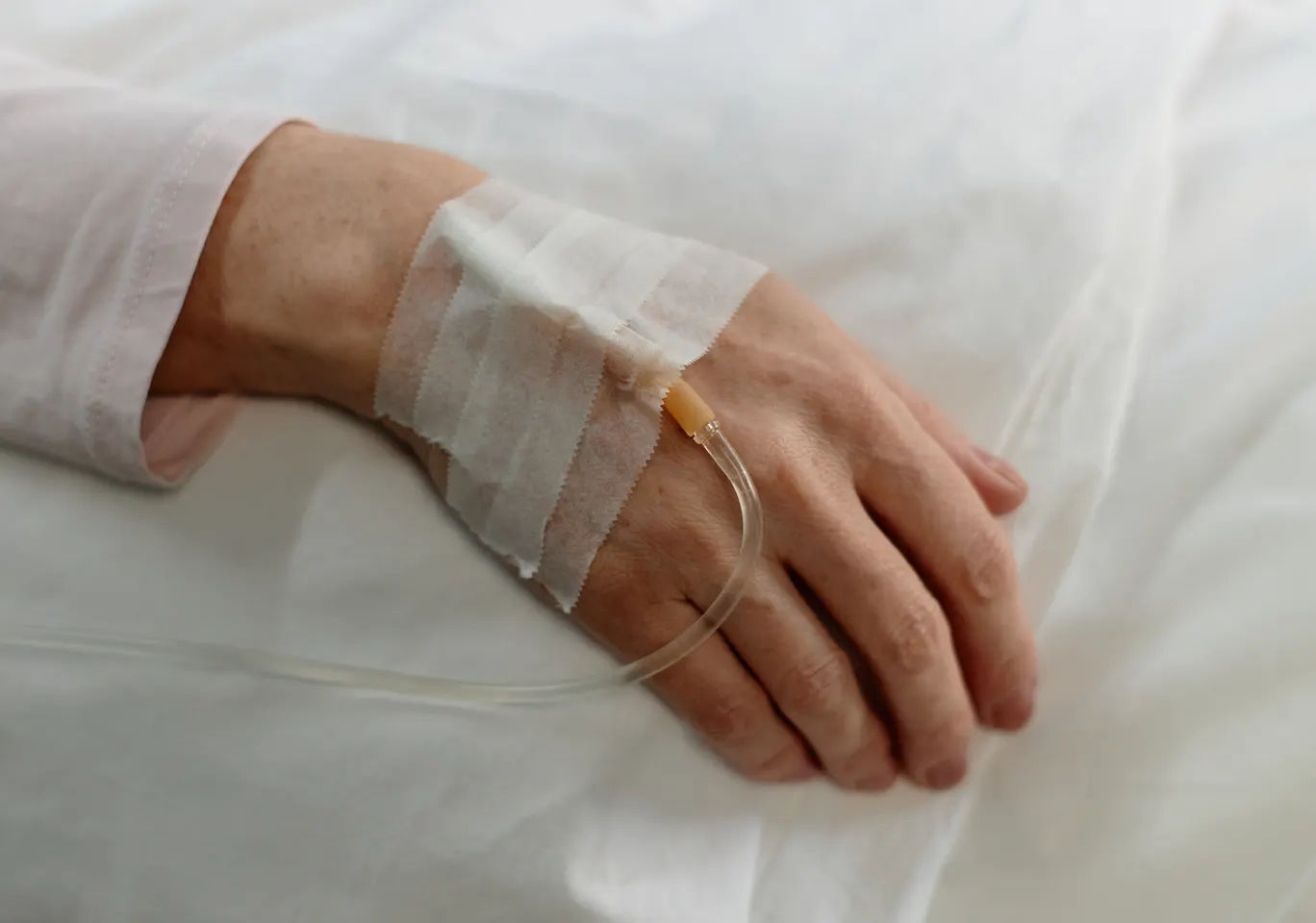 Kroplówki witaminowe Dukla: dłoń z podłączoną kroplówką w spokojnym kadrze