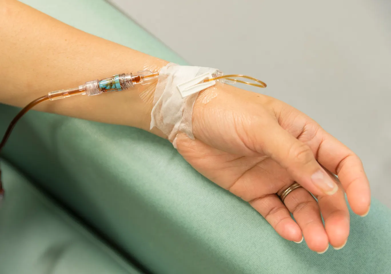 Kroplówki witaminowe Brzozów: dłoń z wenflonem i linią infuzyjną na podkładzie